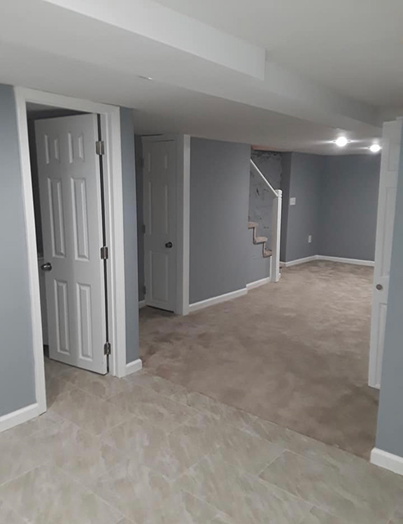 Basement renovation, tile flooring, recessed lightning and light blue painted walls.