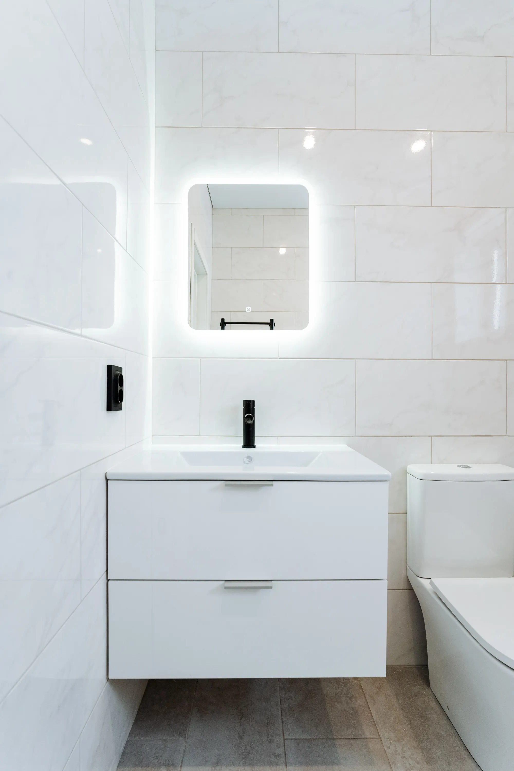 Modern bathroom remodel with floating vanity and LED mirror by DMV Home Improvement