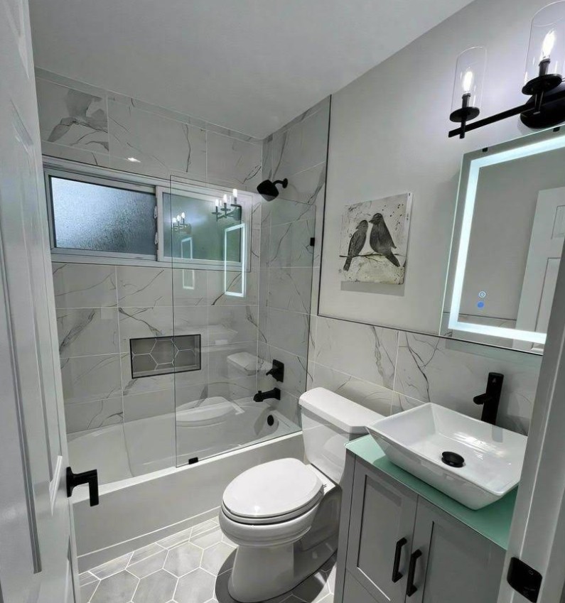 Complete bathroom remodel with marble tile and frameless glass